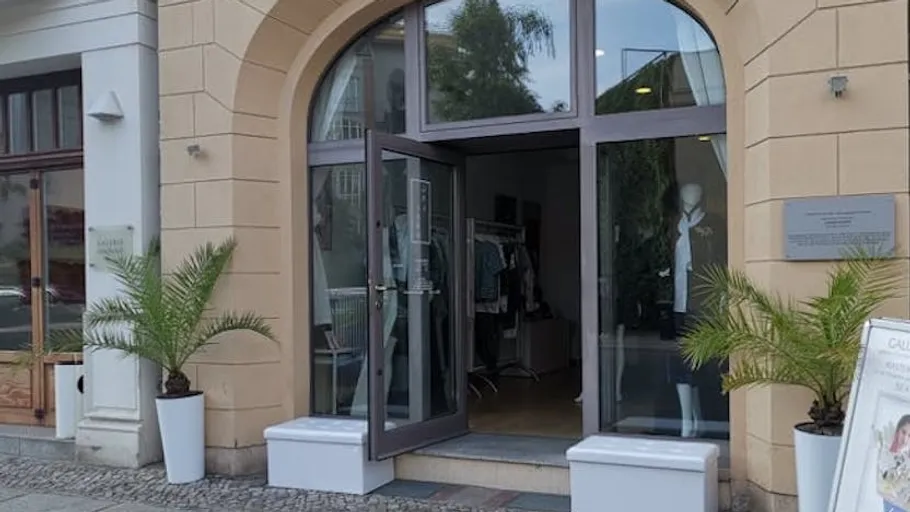 Geöffnete Glastür eines Bekleidungsgeschäfts.