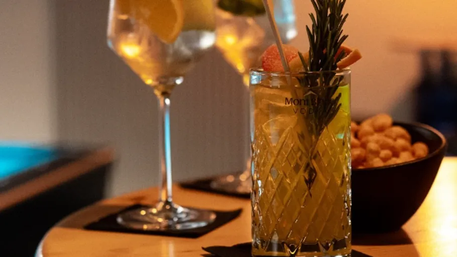 Zwei Cocktails auf Tisch mit Snacks.