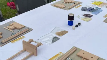Tisch mit Drahtbastelmaterialien im Freien.