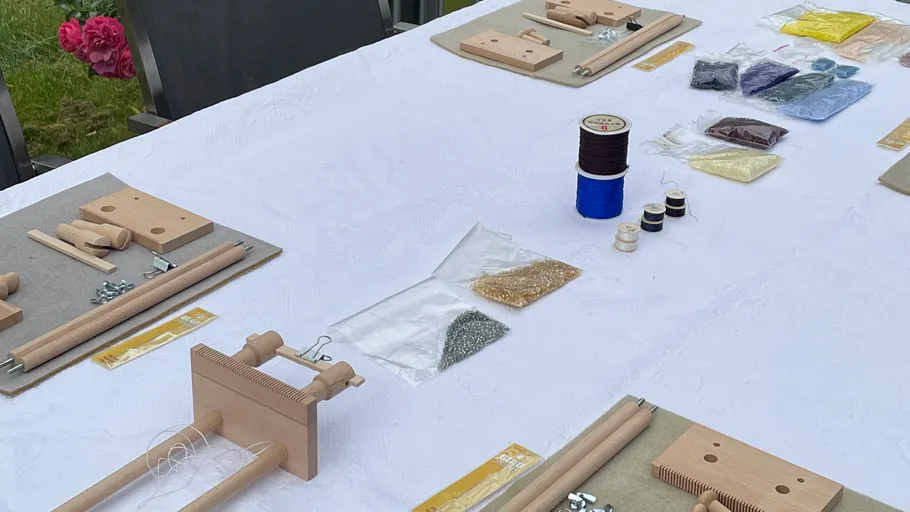 Tisch mit Drahtbastelmaterialien im Freien.