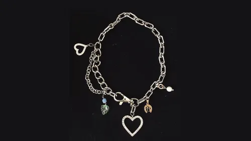 Herzanhänger-Armband auf schwarzem Hintergrund.