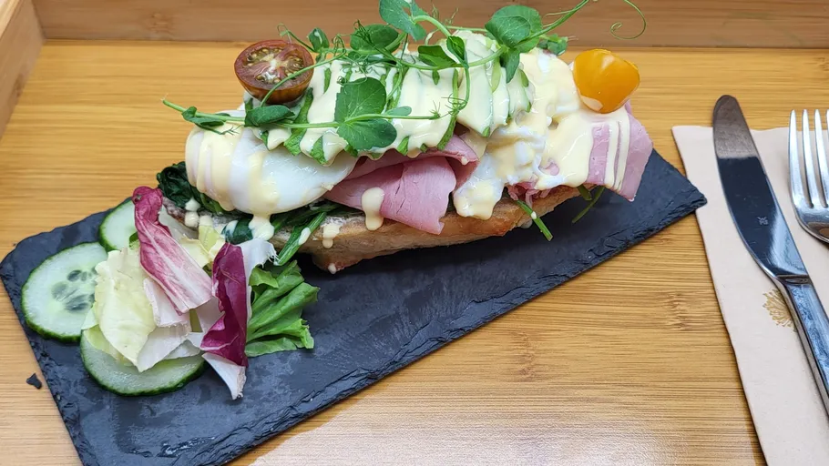 Offenes Sandwich mit Schinken, Ei, Gemüse auf Schiefer.