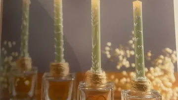 Kerzen mit Herzmotiven in Glasbehältern.