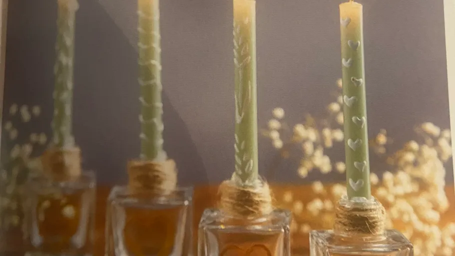 Kerzen mit Herzmotiven in Glasbehältern.