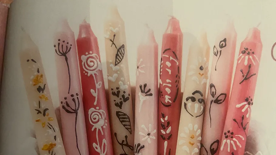 Decorative candles with floral patterns, various colors.