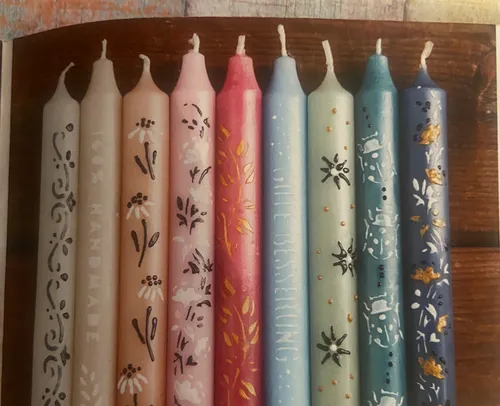 Colorful decorative candles aligned on a wooden surface.