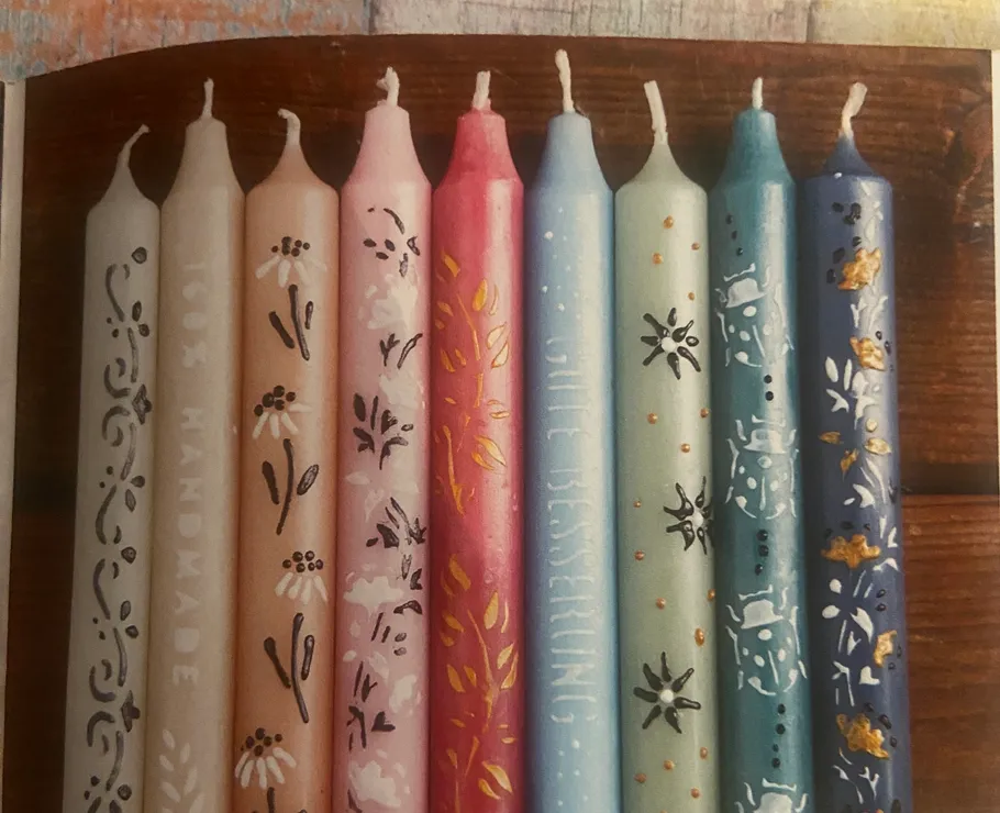 Colorful decorative candles aligned on a wooden surface.
