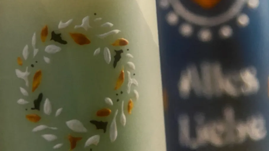 Green candle with leaf design beside blue candle.