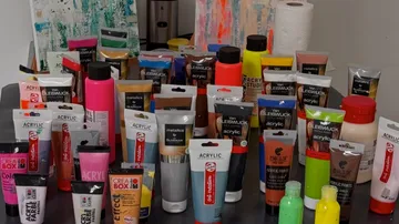 Various acrylic paint tubes on a table.