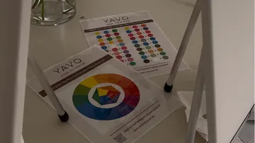Color charts on the floor beneath a chair.