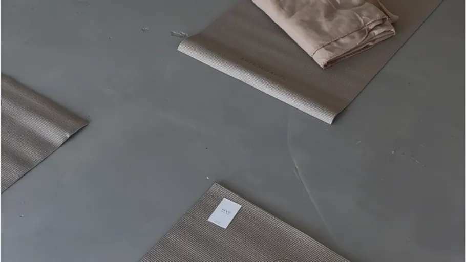 Yoga mats arranged on a gray floor.