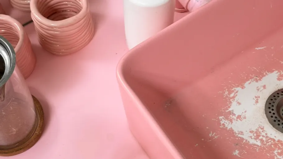 Pink sink with ceramics and glass.