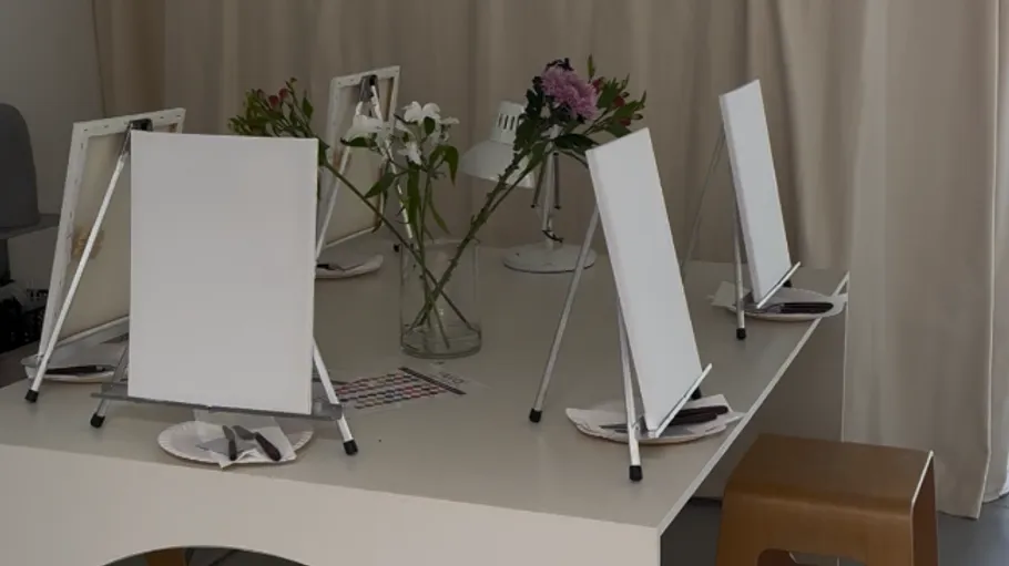 Leinwände auf Staffeleien mit Tischaufbau.