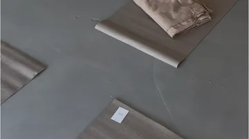 Yoga mats on gray floor with folded towel.