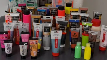 Assorted acrylic paint tubes on a table.