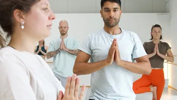 Group practicing yoga poses in a studio.