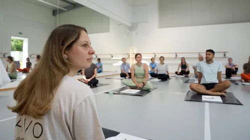 People sitting in a yoga class studio.