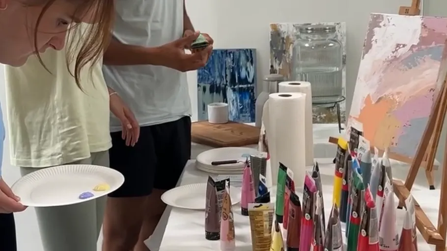 Personen malen mit Acrylfarben an einem Studientisch.