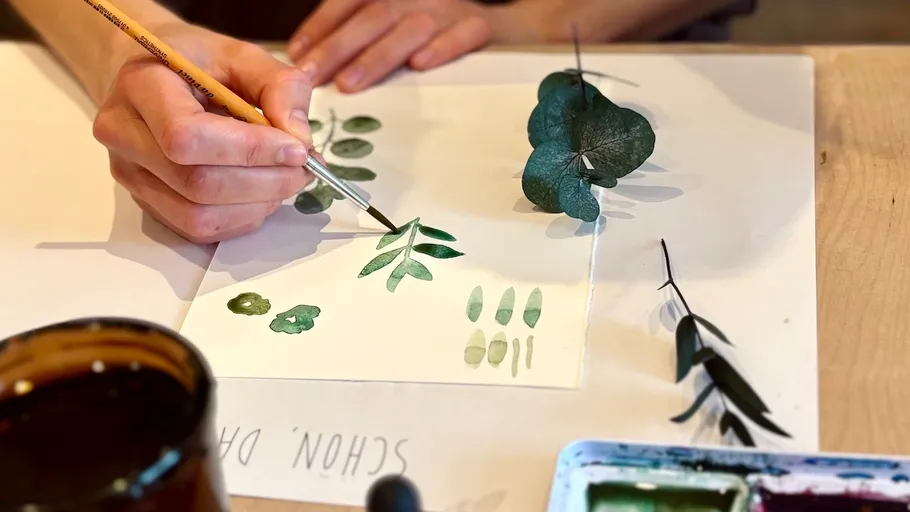 Hand painting leaves on paper, watercolor style.