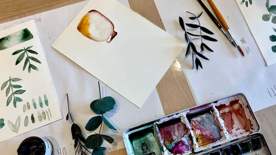 Watercolor painting supplies on a table.