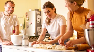 Drei Personen backen gemeinsam in der Küche.