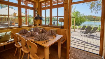 Wooden room with table, lakeside view.