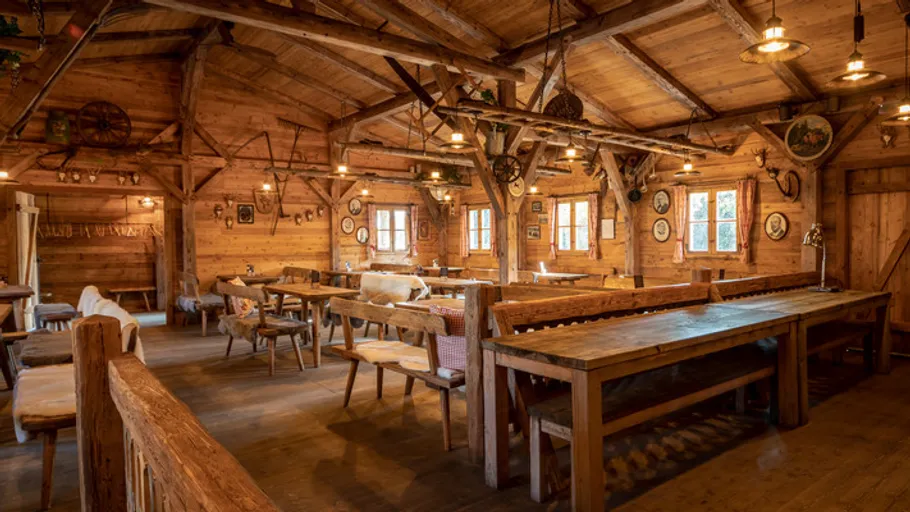 Rustikaler Holzspeisesaal, leere Tische, gemütliche Atmosphäre.