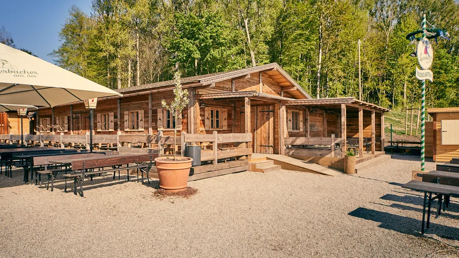 Wooden building with tables in outdoor setting.