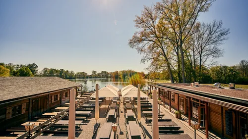 Outdoor dining area beside a serene lake.