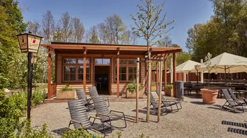 Holzgebäude mit Stühlen im Freien.