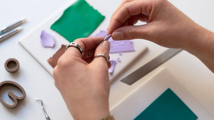 Hände formen Ton auf Handwerkstisch.