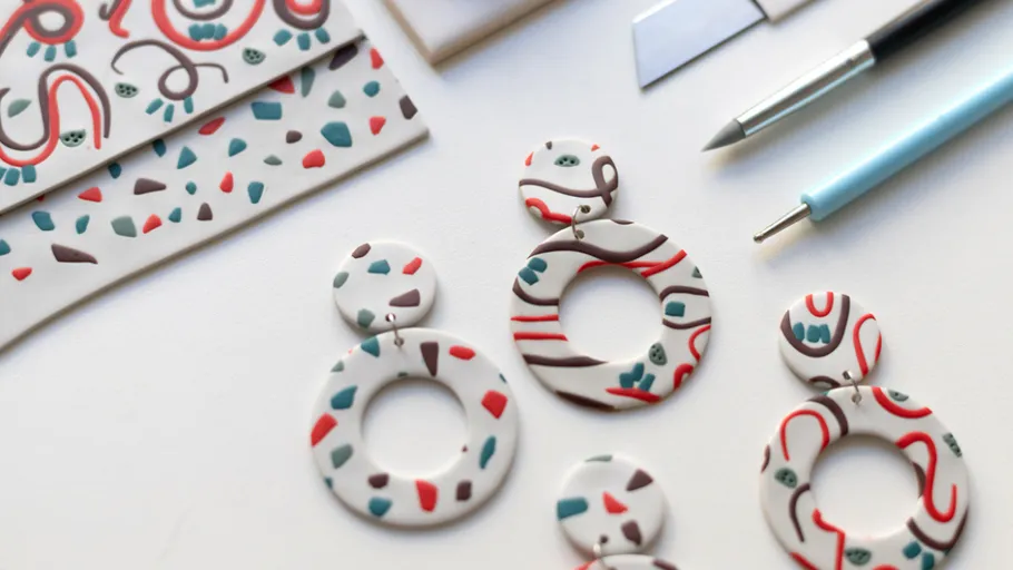 Colorful earrings on a crafting table.