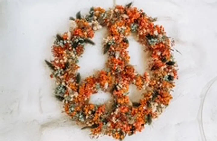 Flower peace sign on white wall.