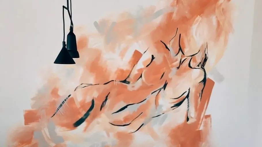 Abstract figure painting on textured wall.