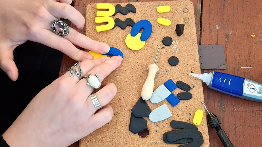 Hands crafting with colorful clay on a board.