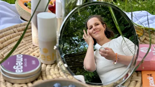 Frau trägt Creme auf, Spiegelung im Freien.