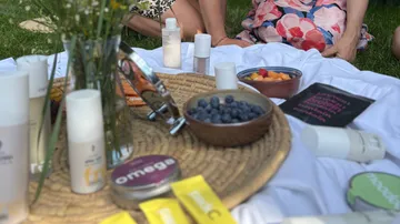 Picknick mit Früchten und Hautpflegeprodukten im Freien.