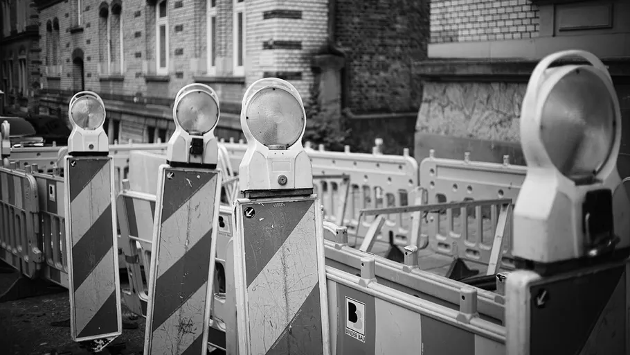 Bauabsperrungen mit Lichtern auf Straße.