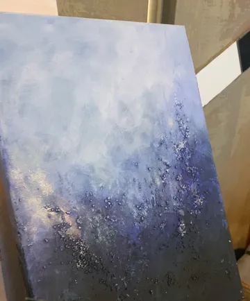 Abstraktes blaues Gemälde an Wand gelehnt.