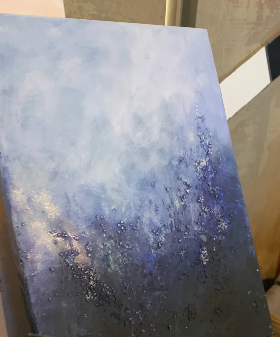 Abstraktes blaues Gemälde an Wand gelehnt.