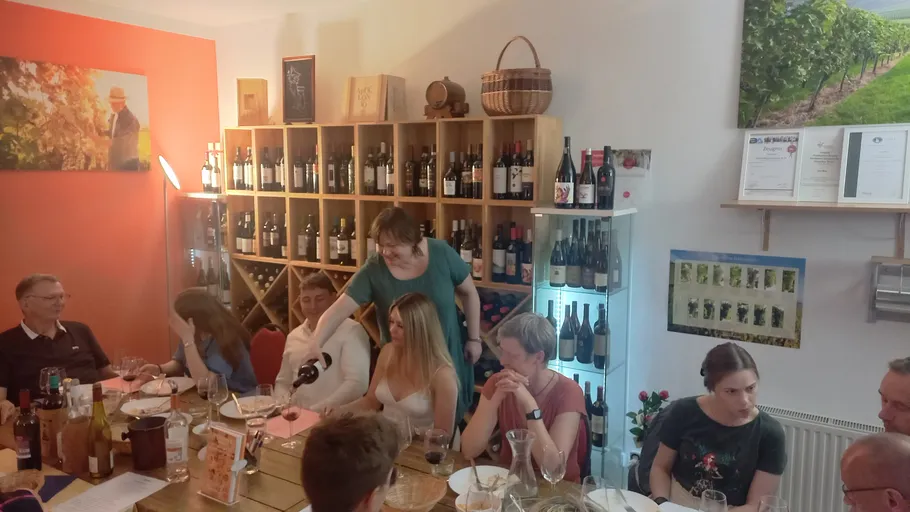 Menschen genießen Wein in einem gemütlichen Raum.