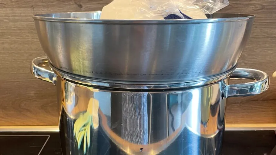 Stainless steel pot with ice in a bowl.