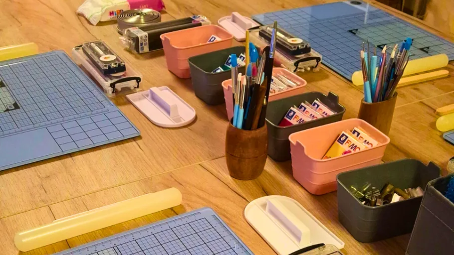 Art supplies arranged on wooden table.