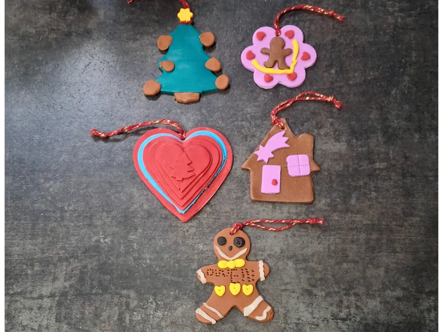 Five colorful clay ornaments on dark surface.