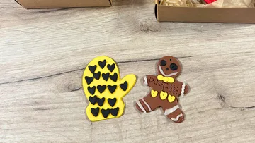 Clay mitten and gingerbread figure on table.