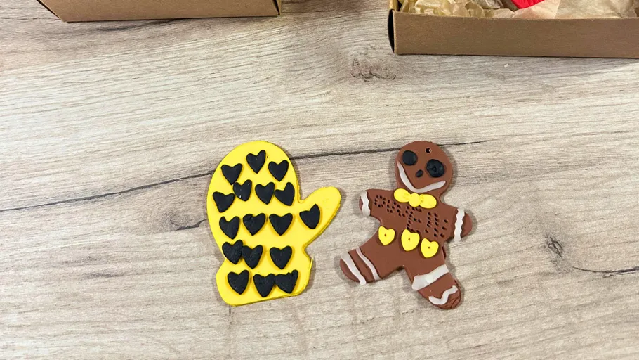 Clay mitten and gingerbread figure on table.