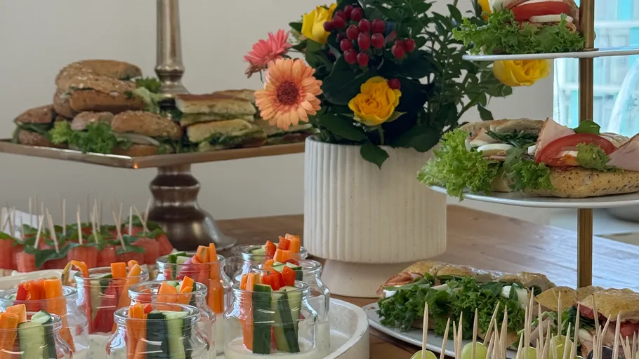Sandwiches and snacks on a wooden table.