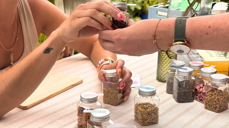 Two people exchanging glass jars over table.