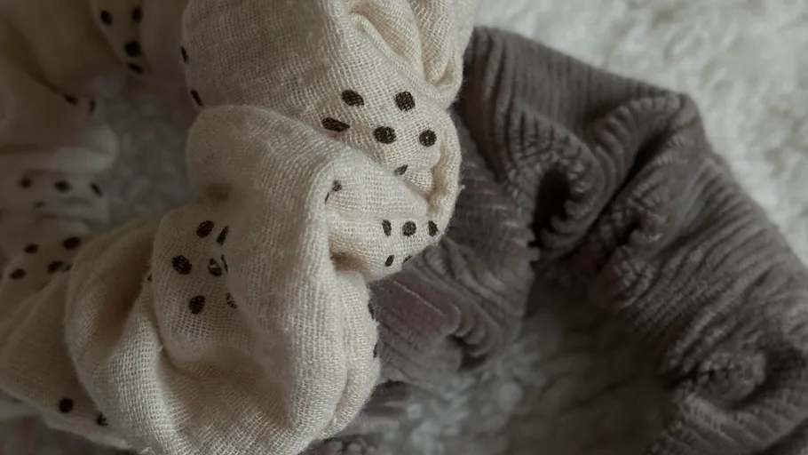 Scrunchies placed on a textured white surface.