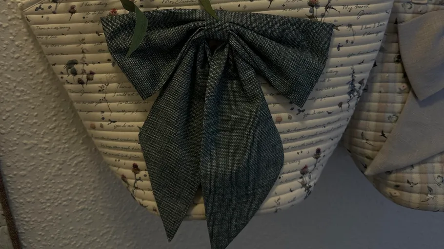 Fabric basket with a large bow decoration.